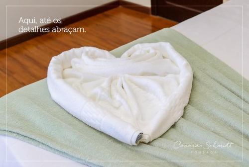 a towel in the shape of a heart on a table at Pousada Casarão Schmidt in Pomerode