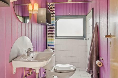 a pink bathroom with a sink and a toilet at 40572-Juelsminde-Pot-Strandby-134 in Sønderby