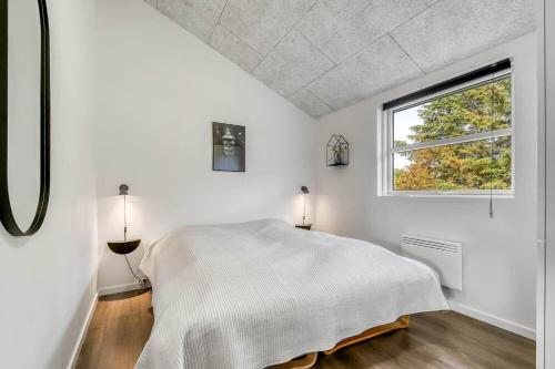 a white bedroom with a bed and a window at C11349-Tarm-Stikkelsbaervej-43 in Tarm