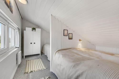 a white bedroom with a bed in a attic at C11726-Hemmet-Vester-Faelled-120-E1 in Hemmet