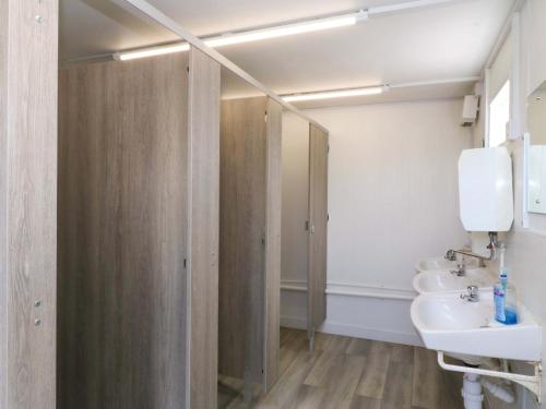 ein Badezimmer mit zwei Waschbecken und einer Dusche in der Unterkunft Cwt Bugail in Pwllheli