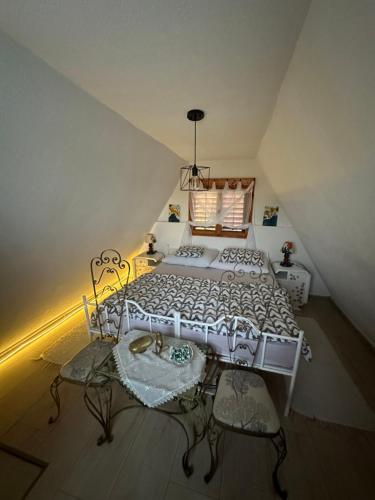 a bedroom with a white bed and two chairs at Two Olives Vacation Homes in Slatina Varoš