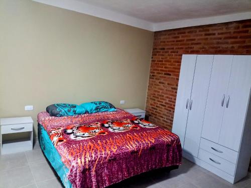 a bedroom with a bed and a brick wall at Atardecer serrano in Mina Clavero