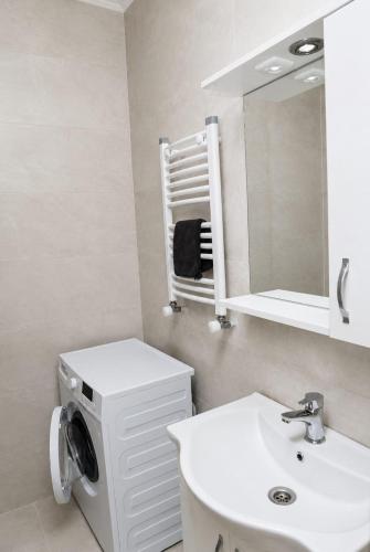 a bathroom with a sink and a washing machine at Cozy apartment in Angisa