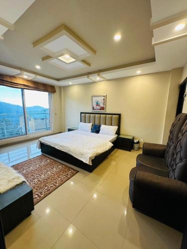 a bedroom with a bed and a couch and a window at Apartment In Ayubia in Naka