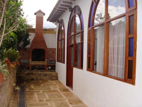 un patio de una casa con ventanas y chimenea en Villa Pepita Real en Villa de Leyva