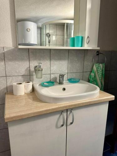 a bathroom counter with a sink and a mirror at Two Olives Vacation Homes in Slatina Varoš