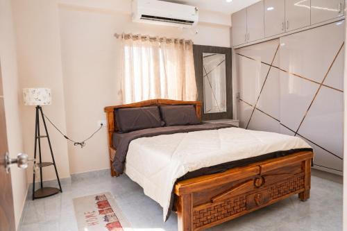 a bedroom with a large bed with a wooden frame at The jaish heaven in Rushikonda