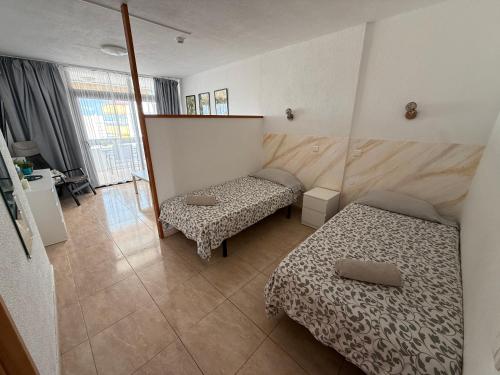 a small room with two beds and a mirror at Marlenghi Apartments 818 in San Bartolomé