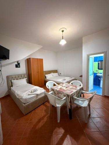 a room with a bed and a table and chairs at Rajan Rooms in Vlorë