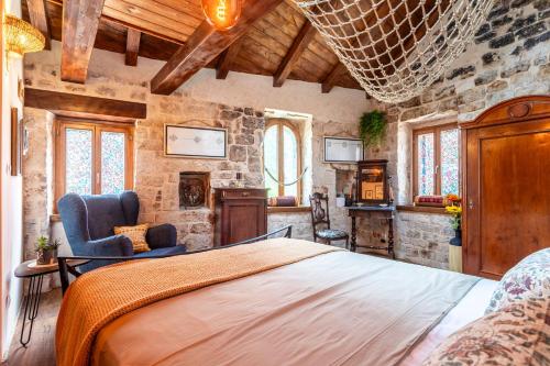 a bedroom with a large bed and a stone wall at House Morski brk in Trogir