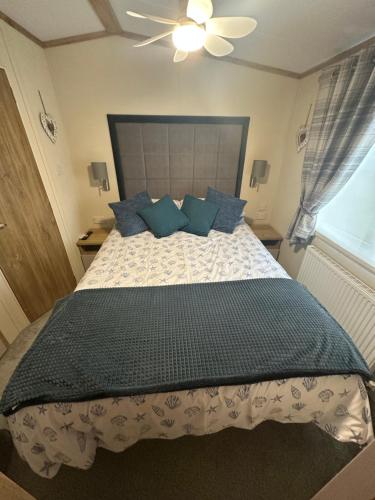 a bedroom with a large bed with blue pillows at Duckpool 108 Bude in Bude