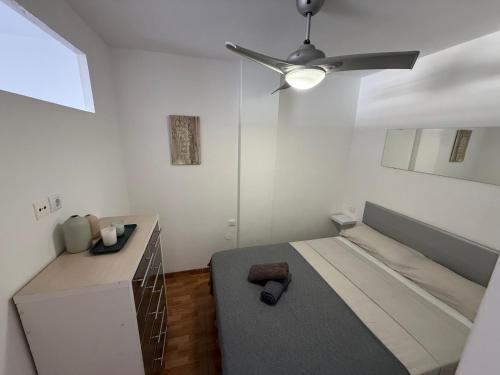 a bedroom with a bed and a ceiling fan at Marlenghi Apartments 412 in San Bartolomé