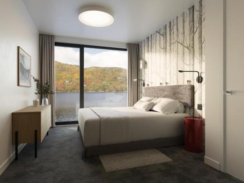 a bedroom with a bed and a large window at Cormorant Rock Chalets in Ingonish Beach