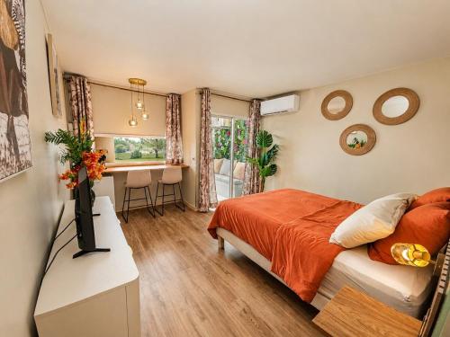 a bedroom with a bed and a desk and a table at Tropical Chic Studio - Marina View - Swimming Pool in Les Trois-Îlets