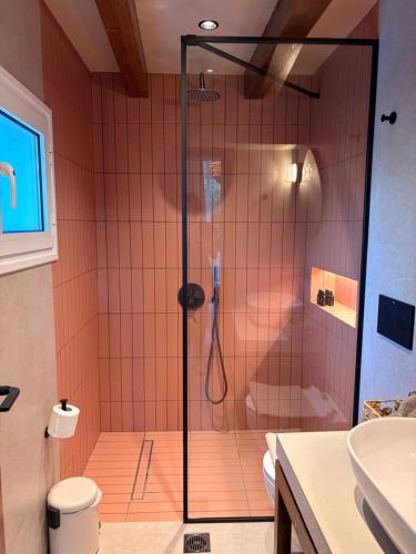 a shower with a glass door in a bathroom at Olive Grove Retreat Paxos in Vlachopoulátika