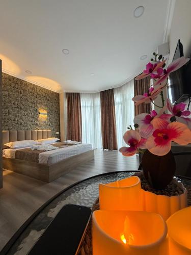 a hotel room with a bed and a vase of flowers at SkyHouse Batumi in Batumi