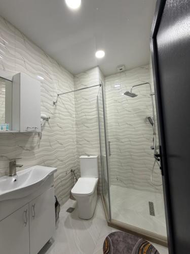a bathroom with a shower and a toilet and a sink at SkyHouse Batumi in Batumi