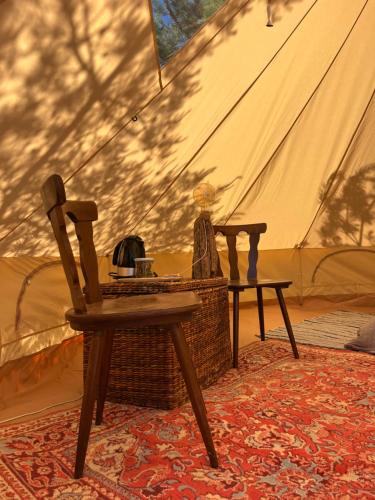 a table and a chair in front of a tent at KEMPINGS Kareļi in Saraiķi