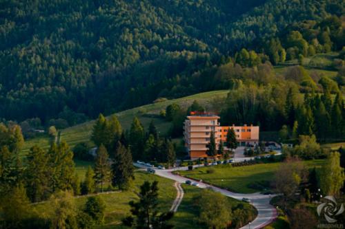 a building on a road in the middle of a mountain at KORONA Sanatorium Uzdrowiskowe in Muszyna