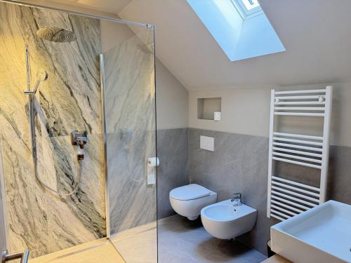 a bathroom with a shower and a toilet and a sink at Riolina Suite in Mühlbach