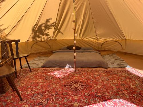 a bedroom with a bed in a tent at KEMPINGS Kareļi in Saraiķi