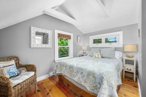 a white bedroom with a bed and a chair at Cape Cod Cottage near Beaches & Downtown in Chatham