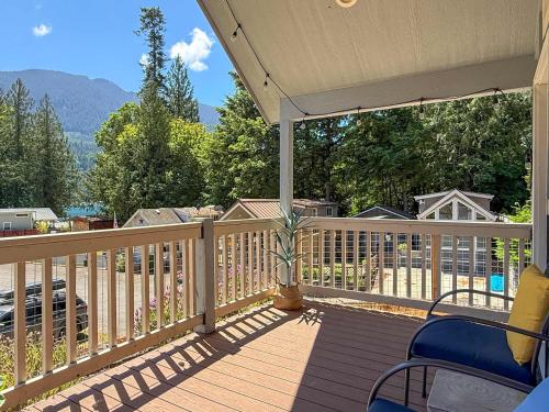 a deck with chairs and a view of the mountains at Lake Sutherland Chalet Tiny home with lake access in Port Angeles
