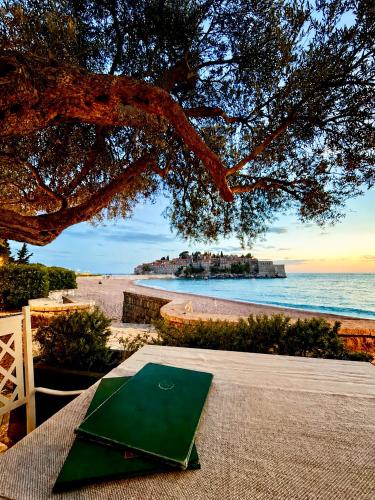 a picnic table on the beach with a view of the ocean at Villa Nemanja in Sveti Stefan
