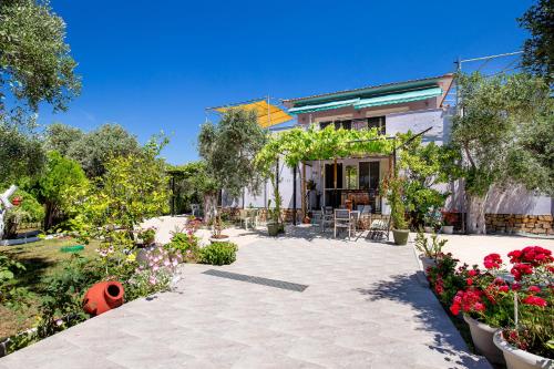 a house with a patio with flowers and plants at Studios Panagiotas House Astris in Astris