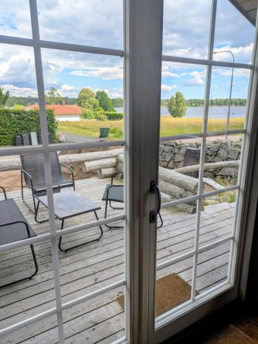 a view through a glass door of a deck with chairs at Cozy Lakeside Adventure - Biberburg am See in Osby