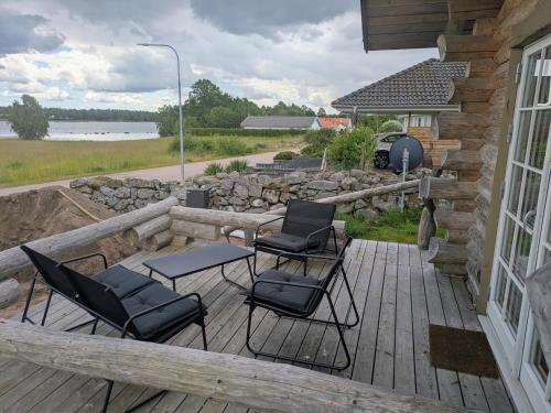 a patio with chairs and a table on a deck at Cozy Lakeside Adventure - Biberburg am See in Osby