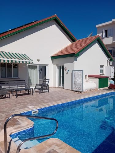 a swimming pool in front of a house at Empa Residence with private pool in Emba