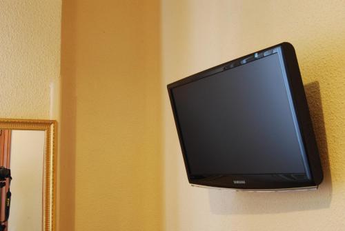 a flat screen tv hanging on a wall at Hostal America in Madrid