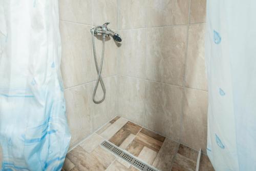 a shower with a shower curtain in a bathroom at Vikendica Na Plivi E&M in Šipovo