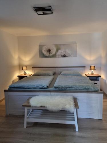 a bedroom with a bed and a table with two beds at Ferienwohnung Lolek in Brilon