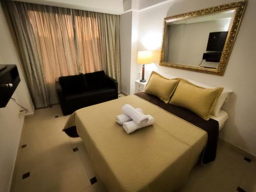 a hotel room with a bed with two towels on it at VM Flats Guarulhos Aeroporto in Guarulhos