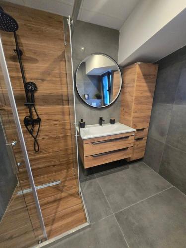 a bathroom with a sink and a mirror at Grey Pearl Apartments in Nea Kallikrateia