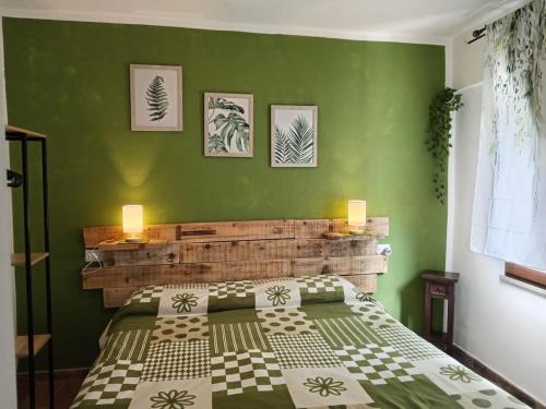 a bedroom with a bed with a green wall at Podere il Gallo Agriturismo in Campiglia Marittima