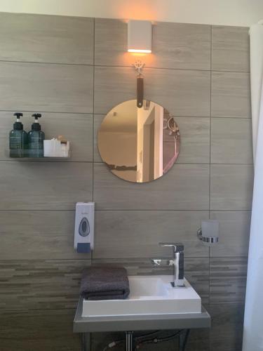a bathroom with a sink and a mirror at Baladise Apartman in Balatonvilágos