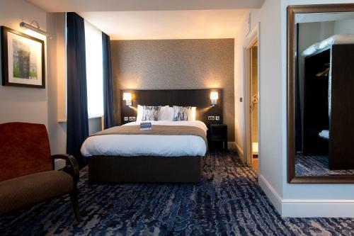 a hotel room with a large bed and a mirror at The Yarborough Hotel Wetherspoon in Grimsby
