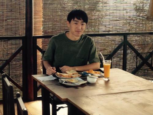 a man sitting at a table with a plate of food at Homies Place - Bistro in Bandarawela