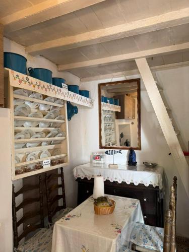 a room with a table and a mirror and a shelf with dishes at Marthas Traditional House in Symi