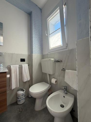 a bathroom with a white toilet and a sink at Al Baglio di Sant'Elia in Santa Flavia