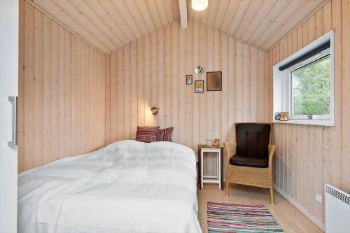 a bedroom with a bed and a chair and a window at 30040-Beder-Hogevaenget-27 in Beder