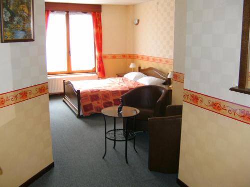 B&B Le Petit Normand في جالهاي: غرفه فندقيه بسرير واريكه وطاولة