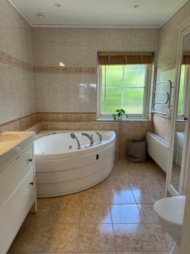 a large bathroom with a tub and a sink at House close to the forest and the lake in Huskvarna