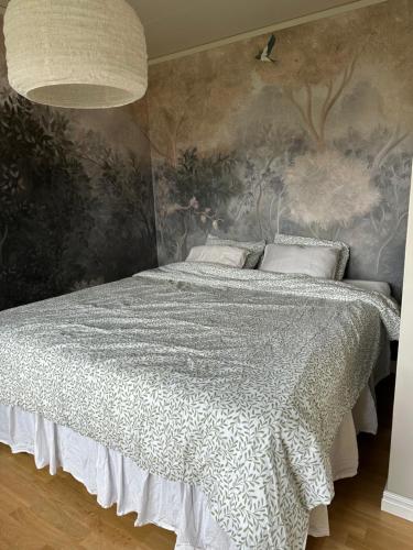 a bedroom with a bed with a wall mural at House close to the forest and the lake in Huskvarna