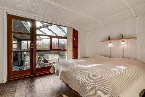 a bedroom with a bed and a large window at C11761-Hemmet-Sydmarken-27 in Falen