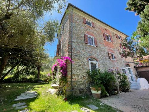 a brick house with flowers on the side of it at Villa Vecchia Fontana al mare - Tra Liguria e Toscana tra Viaregggio, Forte dei Marmi e Cinque Terre- Haus am Meer bei la Spezia in Bocca di Magra
